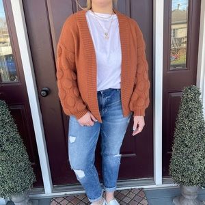Burnt orange knit cardigan with textured poof sleeve